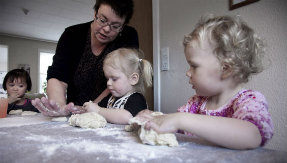 Dagplejer Susanne List og tre dagplejebørn ælter dej